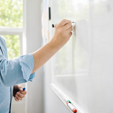 Handen schrijven op een whiteboard